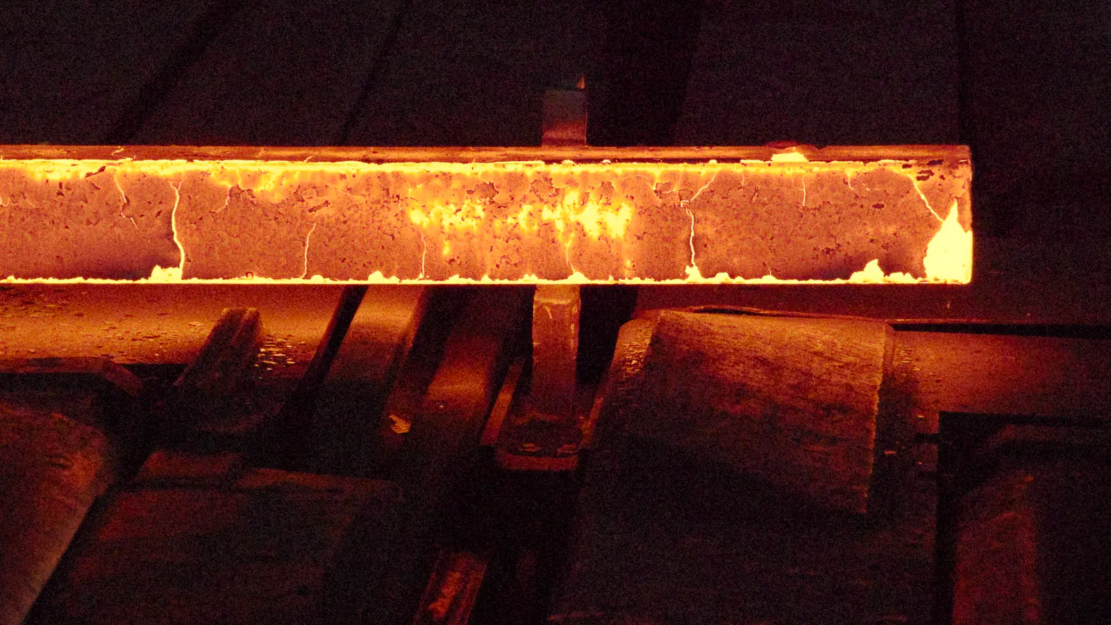 A glowing bar of hot steel on the rolling line of the Huta Pokój steelworks in Ruda Śląska, Poland.